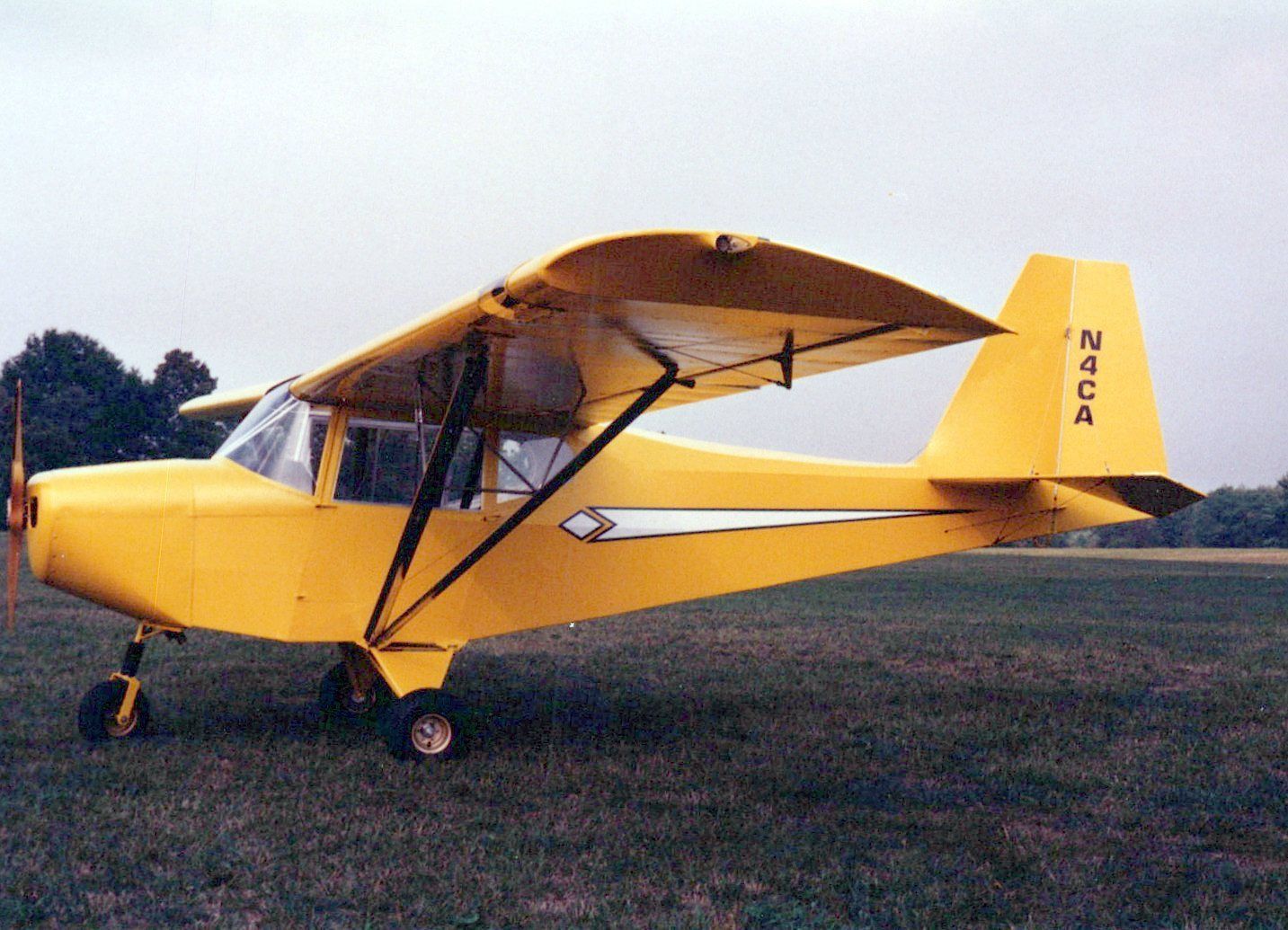 Yellow Carlson Sparrow II XTC parked on a grass field